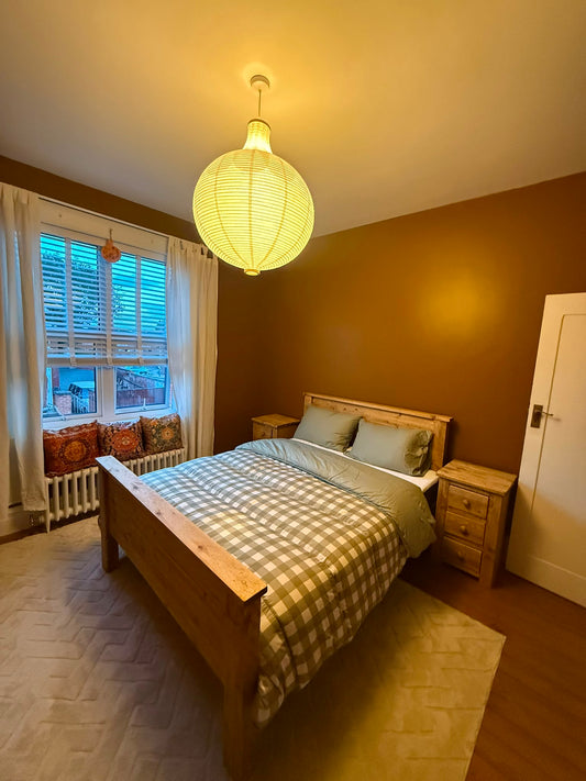 Handmade rustic king-size wooden bed and matching bedside tables in the customer’s completed bedroom